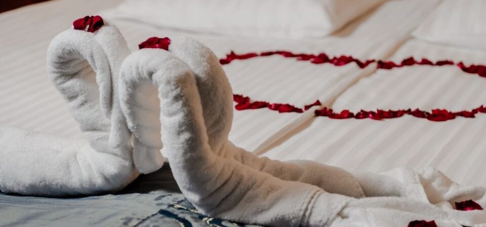 A photo of a honeymoon bed decoration with flowers and towels.