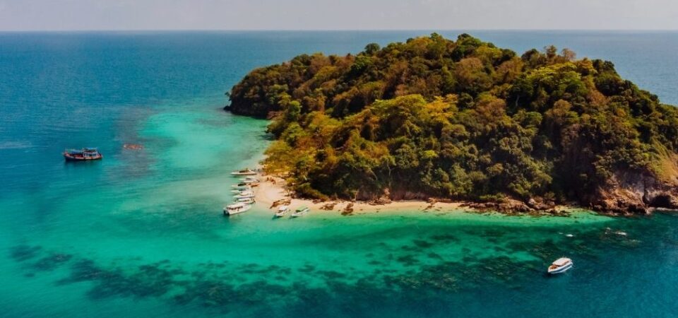 A photo of Manukan Island at Kota Kinabalu, Sabah, with white sand, blue water and green hills.