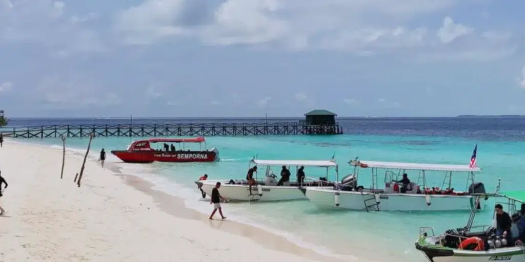 Boats arriving at Pom Pom Island carrying tourists for a day of snorkeling and beach activities