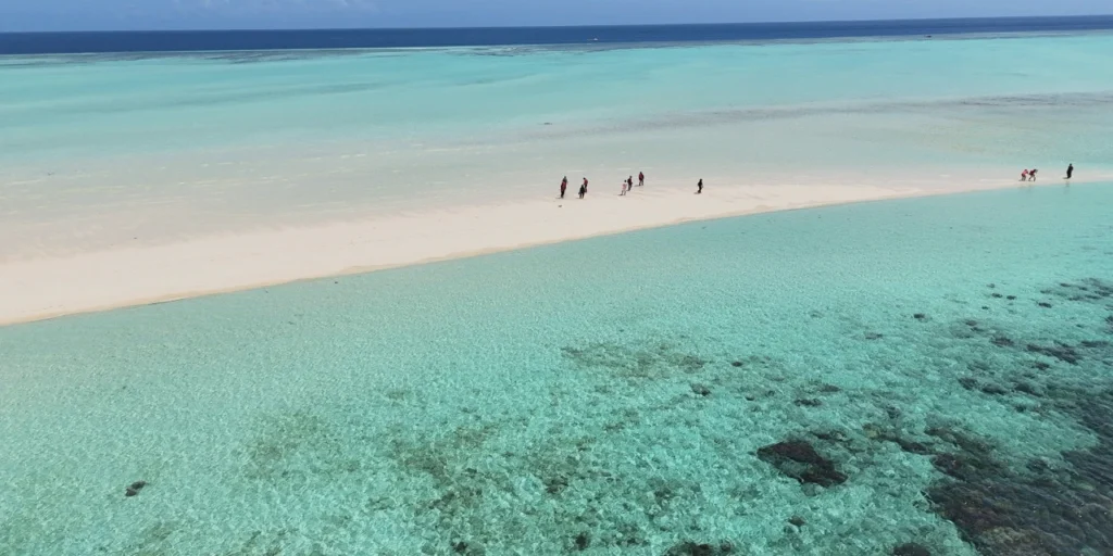 Family enjoying the coastal view of Pandanan Island, Semporna, with clear waters and sandy beaches