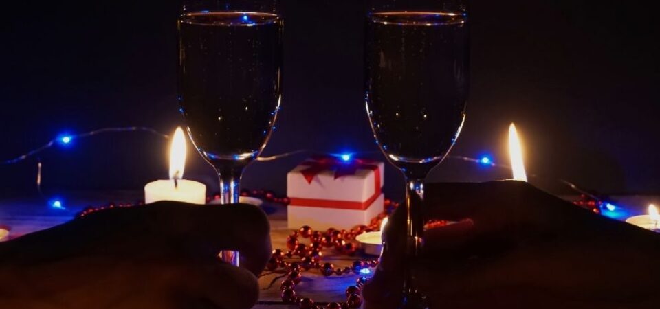 A photo of a candlelit dinner table with flowers and wine glasses.
