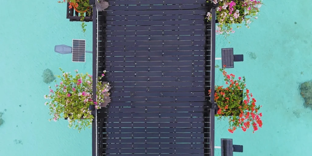 Aerial view of a wooden walkway stretching over the turquoise waters of Mabul Island