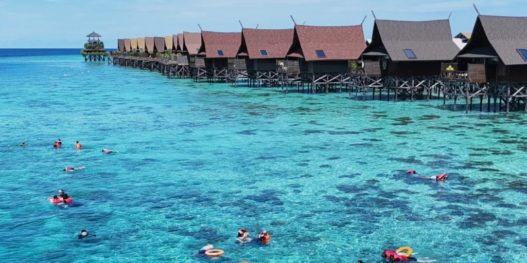 Tourists snorkeling in crystal-clear waters on their Semporna 1-Day Snorkeling Tour
