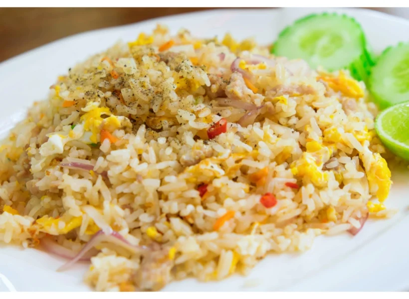 Plate of salted fish fried rice in Sandakan, featuring golden rice with crispy bits of salted fish, egg, chilies and red onions.